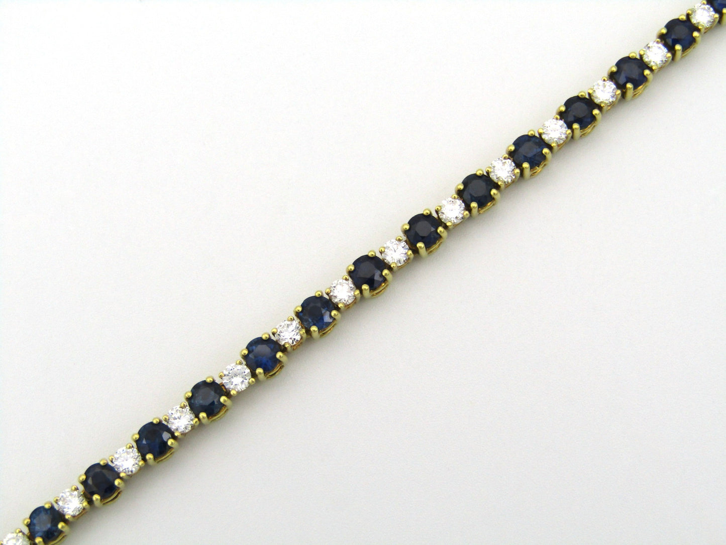 18K gold sapphire and diamond tennis bracelet.