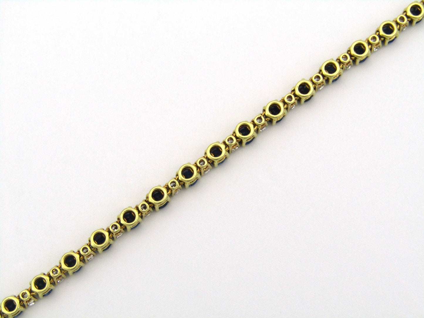 18K gold sapphire and diamond tennis bracelet.